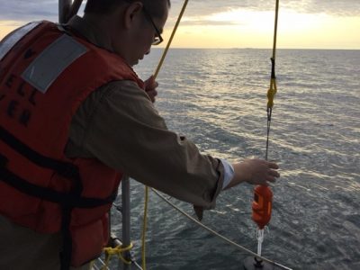 Marine sciences graduate student Yan Ji lowers a CTD profiler into the waters of Long Island Sound during an Aug. 24 research cruise.