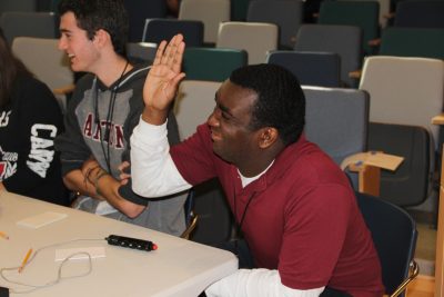 Canton High team member Jadyn Ide-Pech raises his hands to challenge the answer to a question about the world's largest island.