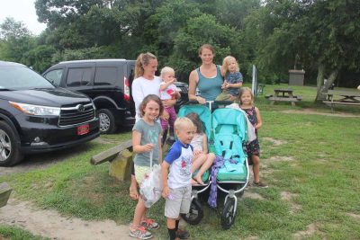 Rachel Aspinwall, rear left, and Catherine Newbury, rear center, collected trash while they walked at Bluff Point State Park on Aug. 1.