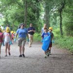 Mystic Aquarium summer campers head out on the main trail at Bluff Point State Park with trash bags and gloves to pick up trash.