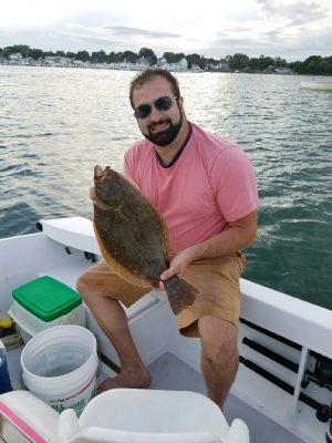 Dan Bergeron shows a summer flounder he caugh tthis summer in Niantic Bay while fishing with his father Roy, who took the photo.