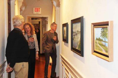 Artist Liane Philpotts of Madison, center, a member of the Connecticut Plein Air Painters Society, talks about her work to visitors at the "Crosscurrents" opening.