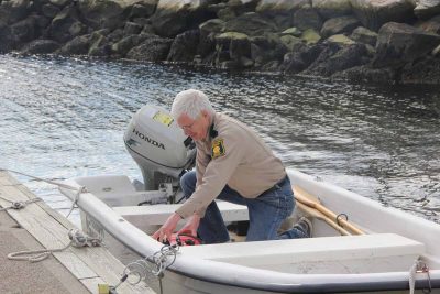 Richard Conant, deputy shellfish warden for Groton, checks the fuel in the boat he uses to collect water samples from the town's recreational shellfishing beds.