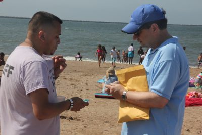 Robert Burg, right, communications coordinator for the Long Island Sound Study, gives Protect Our Wildlife stickers to YWCA summer camp teacher Justin Del Rio for the campers.
