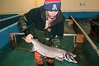 Woman holding salmon.