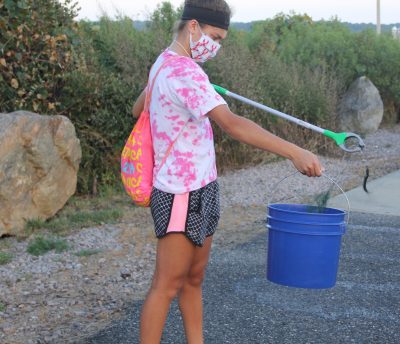 Aria Lupo, a freshman at Princeton University, places a discarded fishing lure with line attached into her bucket.