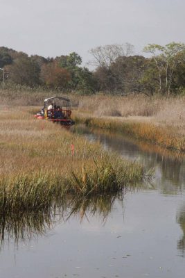 A dredging machine removes silt from Old Field Creek as part of the floodplain restoration project.