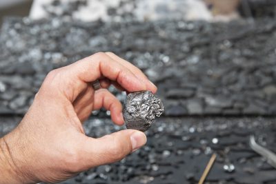 Joseph Smolinski holds one of the pieces of sea coal found on a Long Island Sound beach.