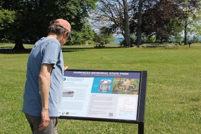 A visitor to Harkness Memorial State Park in Waterford reads the CT Blue Trail Sign installed there.
