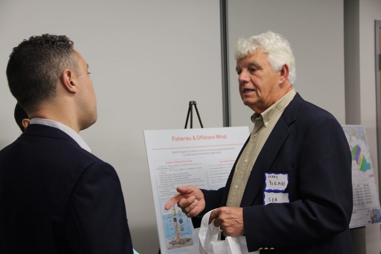 Gary Yerman, right, owner of New London Seafood Distributors, talks with a representative of Equinor, developers of the Beacon Wind project, at a public meeting at Mystic Seaport on Oct. 3.