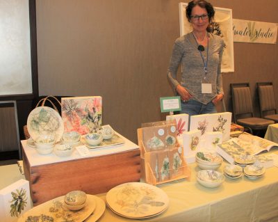 Mary Jameson, artist with Saltwater Studio of Newport, R.I., displays pottery, cards and prints with seaweed designs during the showcase.