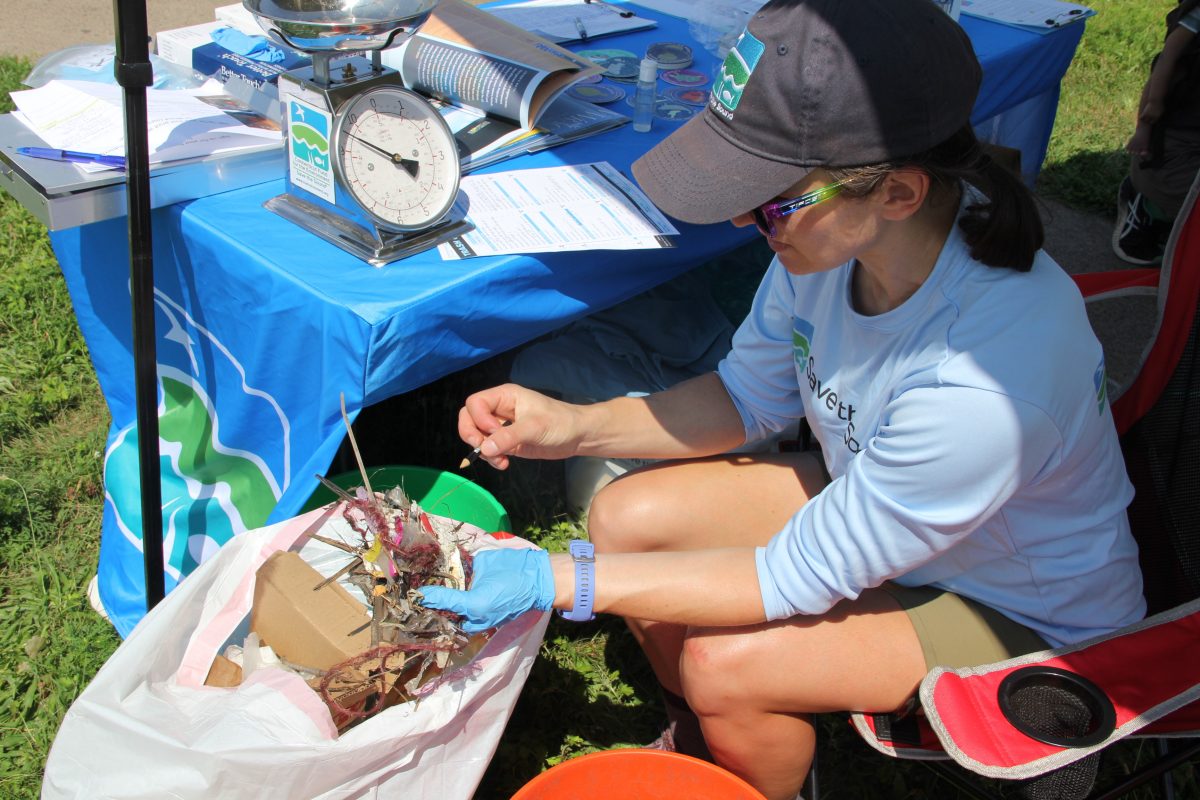 Annalisa Paltauf, ecological restoration assistant and volunteer coordinator for Save the Sound, sorts through a tangle of trash as she tallies the contents of one of the buckets filled at the cleanup.