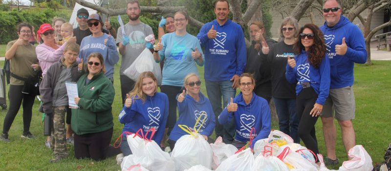 Group photo of volunteers who cleaned Rocky Neck State Park with bags of trash