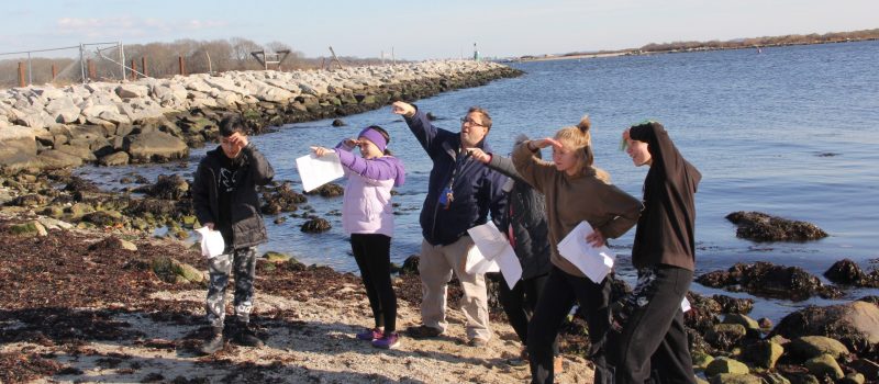 Some of the 80 students who participated in the the LEARN Sustainers of the Sound program supported by CT Sea Grant look from the beach at the Avery Point campus during a scavenger hunt activity. The Dec. 13 program included fish painting and a lesson on Long Island Sound.