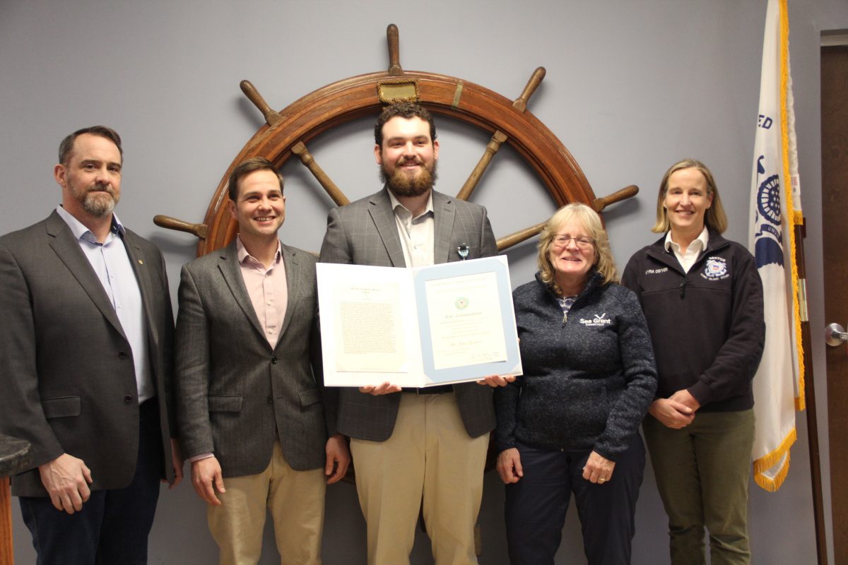 John Genther, center, holds the Meritorious Public Service Award he received from the Coast Guard. Beside him are, from left, John Roberts and Don Orchard of Fishing Partership Support Services, Nancy Balcom of CT Sea Grant and Kyra Dwyer of the Coast Guard.
