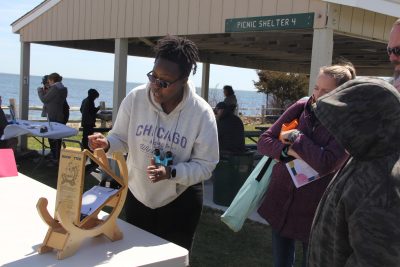 Kym Powe of the CT State Library shows a family how to use the Sunspotter to view the eclipse.