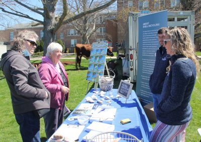 Tessa Getchis, right, CT Sea Grant aquaculture extension specialist, and Mike Gilman, CT Sea Grant aquaculture extension staff member, talk to visitors about shellfish in local waters during the Earth Day event.