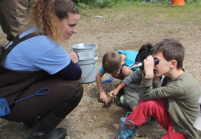 Delaney Vaudrey, a Connecticut National Estuarine Research Reserve intern, shows a Flanders Elementary School student how to use a salinity refractometer during the Rocky Neck State Park Field Experience on May 30.
