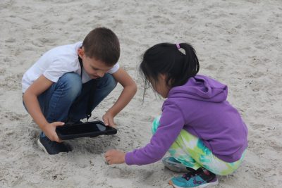 Flanders Elementary school students use an iPad to photograph items found during a beach treasure hunt at Rocky Neck State Park in East Lyme, CT.