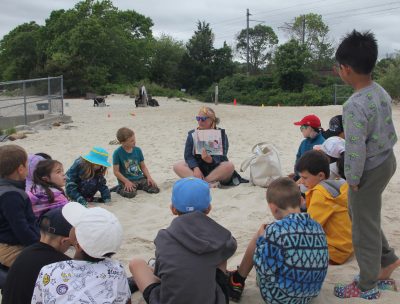 Flanders Elementary School teacher Laura Moore reads a story to her students on the beach to conclude the Rocky Neck Field Experience.