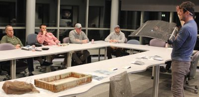 Instructor Mike Gilman, right, explains the use of flip bags for oyster aquaculture to a few of the students in the 2024 Foundations of Shellfish Farming course.