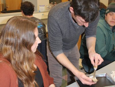 Assistant Extension Educator Mike Gilman shows a student in the 2025 Foundations of Shellfish Farming class how to dissect an oyster.