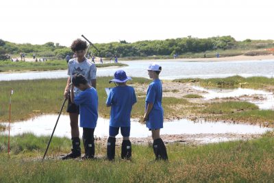 A high school student teaches elementary students about a local salt marsh as part of the Long Island Sound Schools Network project.