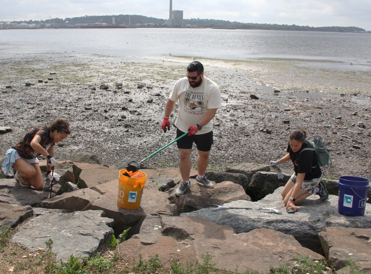 Volunteers pried dozens of pounds of trash trapped in the rocks on the shoreline along Long Wharf Drive in New Haven during the 2025 #DontTrashLISound kickoff cleanup.