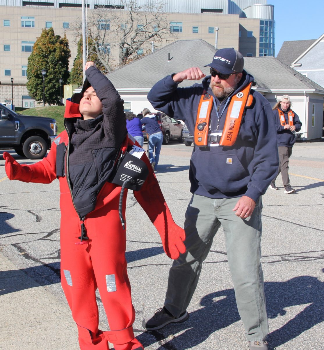 John Quill of Fishing Partnership, right, instructs Alexandra Frenzel, a UConn marine sciences graduate student, how to put on an immersion suit as other students watch.
