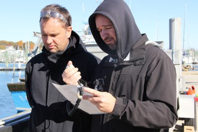 Fisherman Pavel Ivanov, right, practices making a mayday call.