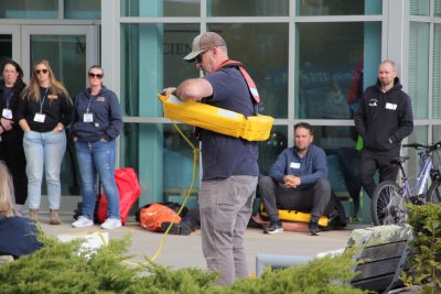 John Roberts of Fishing Partnerships demonstrates how one type of personal flotation device that can be thrown to a person overboard is worn.