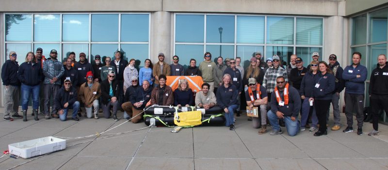 Participants, instructors and organizers of the Fishing Partnership Safety & Drill Trainings hosted by CT Sea Grant gather around a life raft at the end of the first of the two-day workshop Oct 27 & 28. At center in the life raft is Nancy Balcom, CTSG associate director.