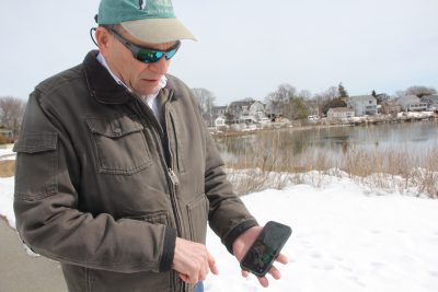 Joe Orchardo shows a photo he uploaded to the MyCoast app of flooding in his neighborhood.