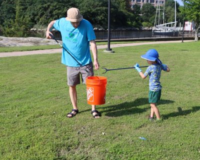 Brendon Albertson, left, and his son Soki collect trash at Fort Trumbull State Park in New London on Aug. 8 during the 2026 #DontTrashLISound campaign kickoff.