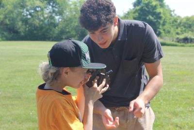 A Waterford High School student shows an elementary schooler how to use a sextant.